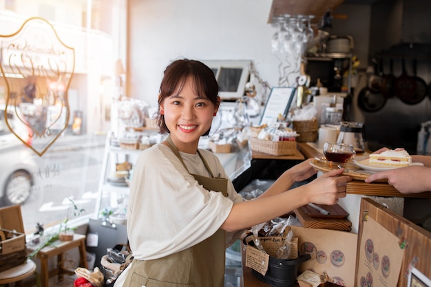 Free photo young woman arranging her cake shop