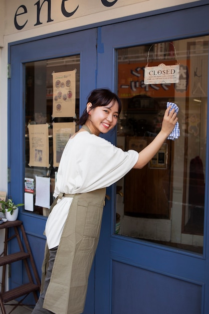 Free photo young woman arranging her cake shop