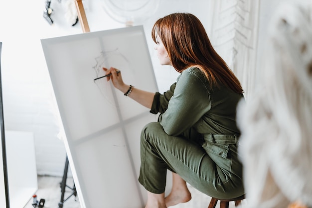 Free photo young woman artist drawing painting in studio