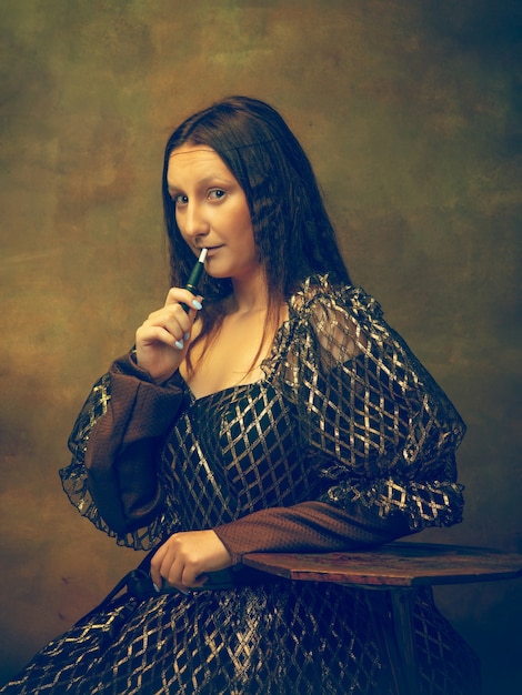 Free photo young woman as mona lisa, la gioconda isolated on dark green