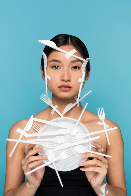 Free Photo young woman being covered in white plastic tableware