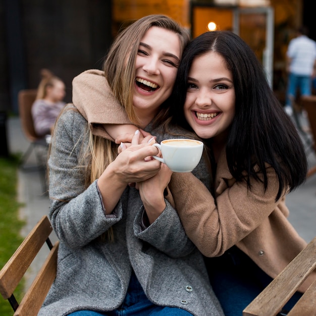 Young woman being hugged by her friend