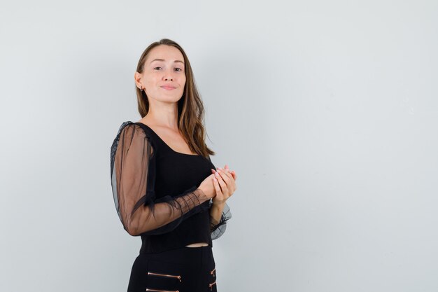 Young woman in black blouse looking forward and looking fresh 