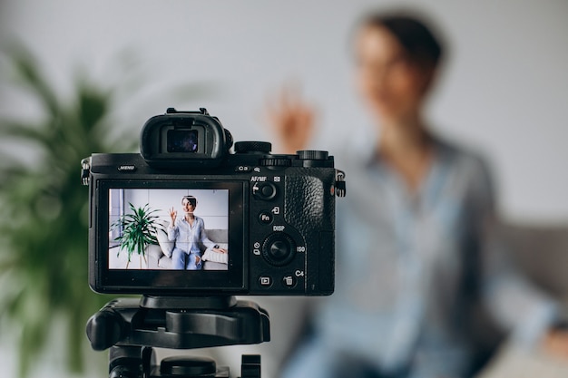 Young woman blogger recording video on camera