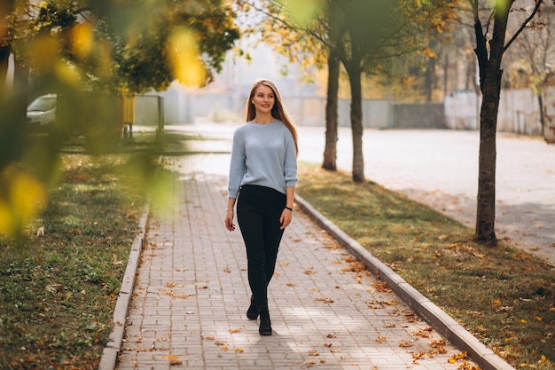 Young woman in blue sweater in autumn park