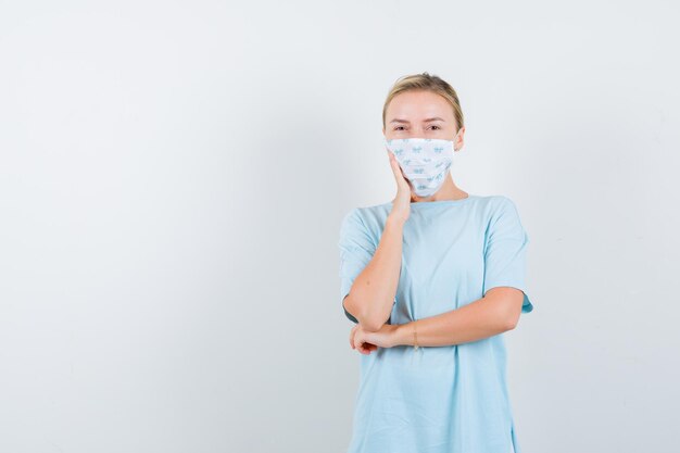 Young woman in a blue t-shirt with a medical mask