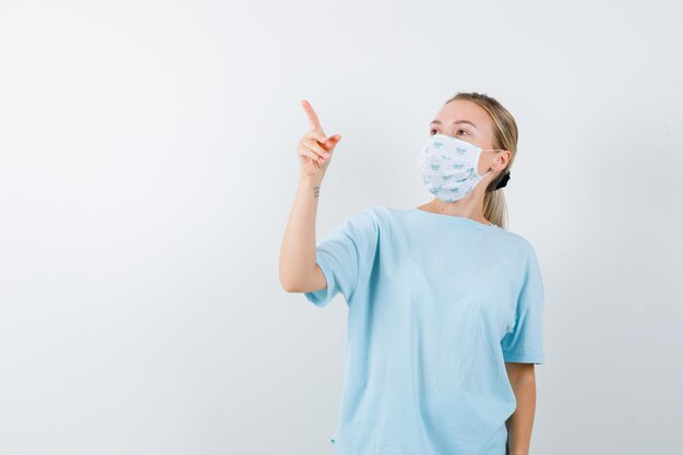 Young woman in a blue t-shirt with a medical mask