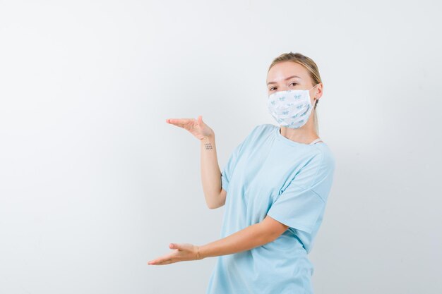 Young woman in a blue t-shirt with a medical mask