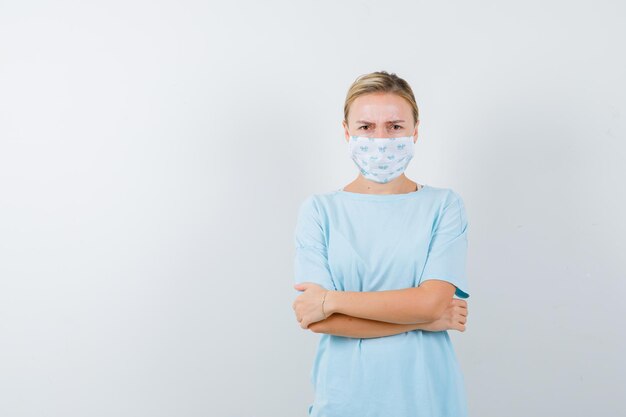 Young woman in a blue t-shirt with a medical mask