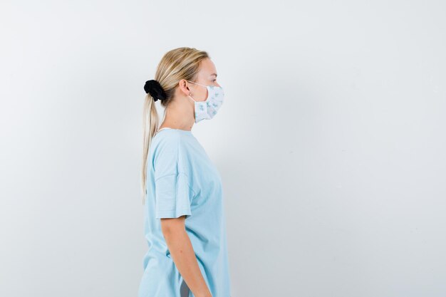 Young woman in a blue t-shirt with a medical mask