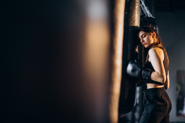 Young woman boxer training at the gym