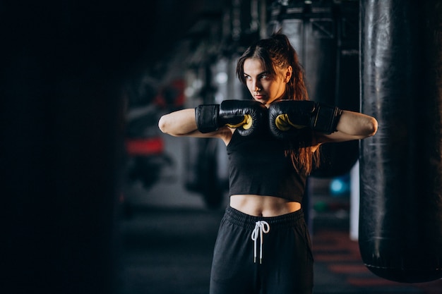 Young woman boxer training at the gym