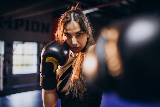 Young woman boxer training at the gym