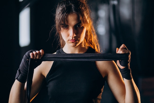 Free photo young woman boxer training at the gym