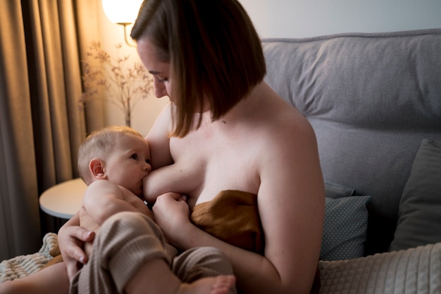 Young woman breastfeeding her cute baby