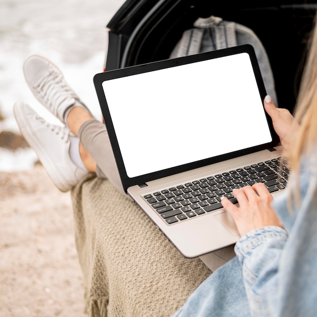 Free photo young woman browsing laptop on road trip