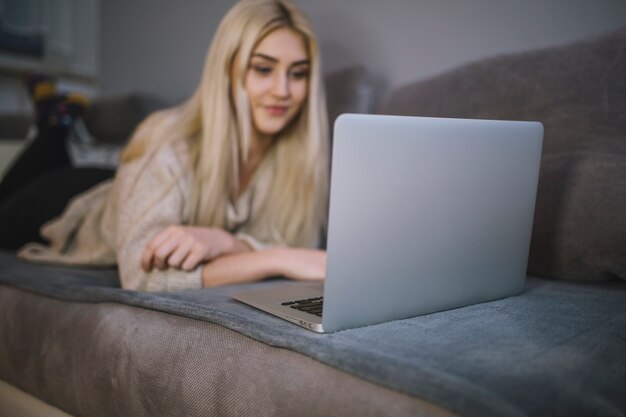 Young woman browsing laptop on sofa