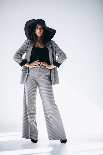 Young woman in a business suit wearing a hat