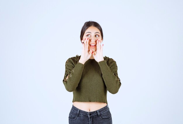 young woman calling for someone on white background.