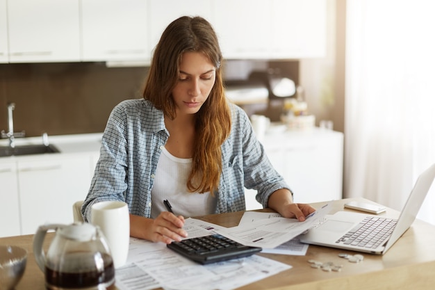 Young woman checking her budget and doing taxes