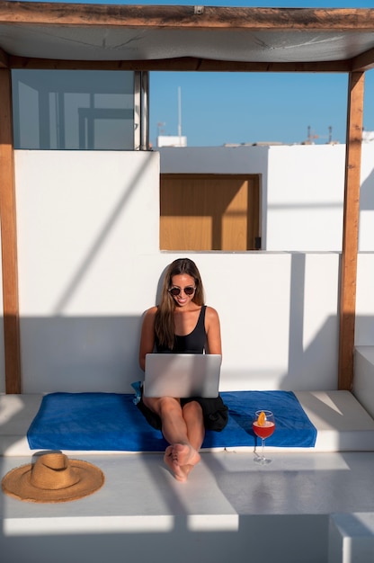 Free photo young woman checking her laptop while being on vacation