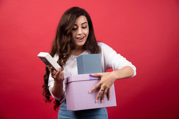 Young woman checking out blue present box. High quality photo