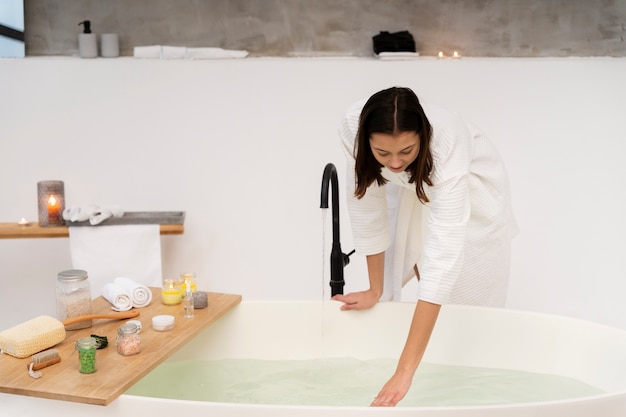 Young woman checking the water before taking a bath