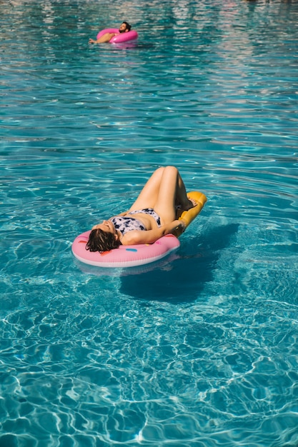 Free Photo young woman chilling on inflatable mattress in pool