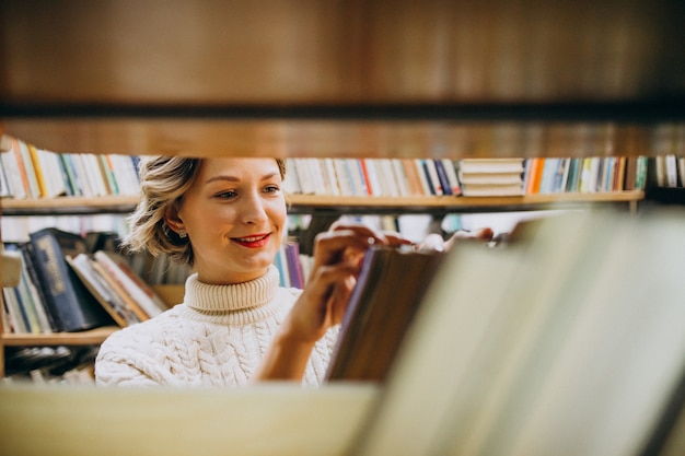 Free photo young woman choosing book at the library