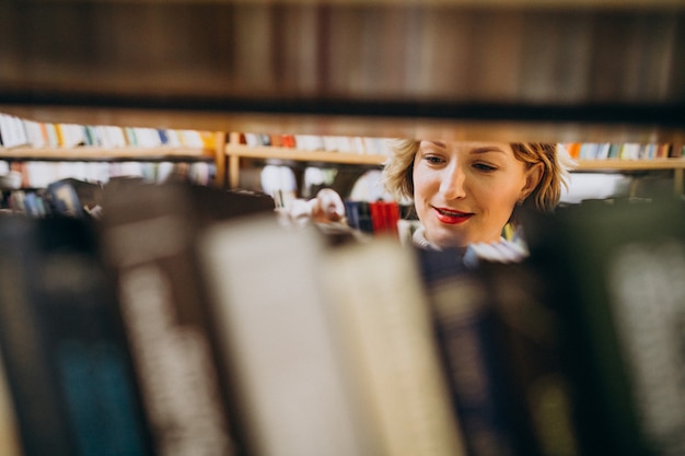 Free Photo young woman choosing book at the library