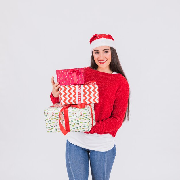 Young woman in Christmas hat and present boxes