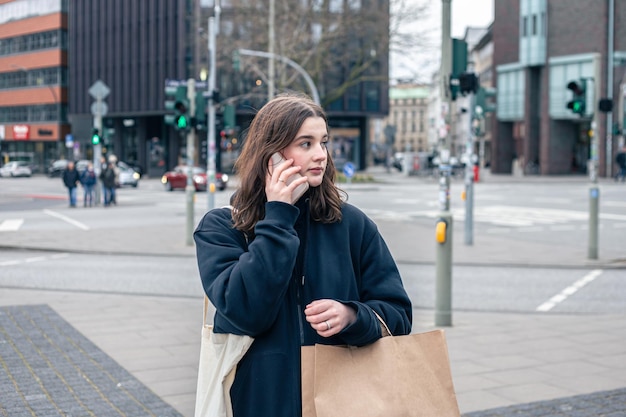 A young woman in the city on the street with a package shopping concept