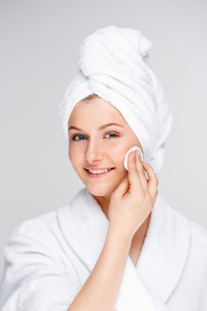 Young woman cleansing face after makeup