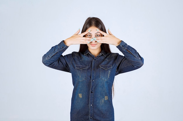 Free Photo young woman closing her eyes or part of face and looking through her fingers