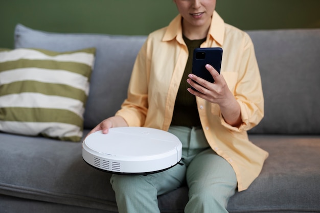 Free photo young woman configuring electronic cleaning device