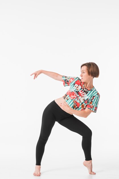 Young woman dancing against white background