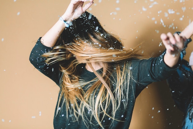 Young woman dancing under snow