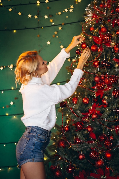 Young woman decorating Christmas tree