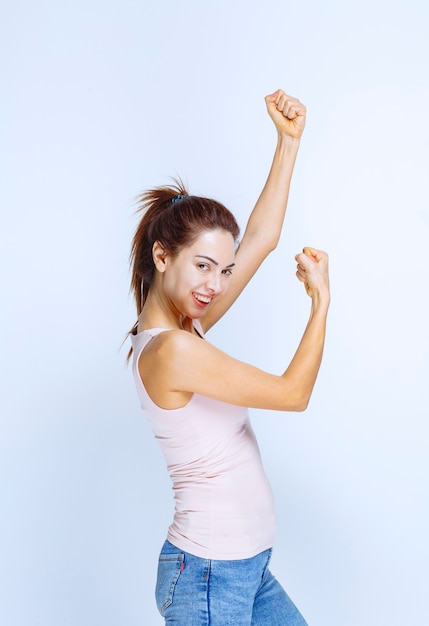 Young woman demonstrating her arm muscles, profile view