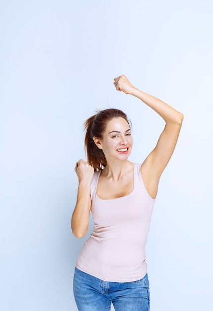 Young woman demonstrating her arm muscles, profile view