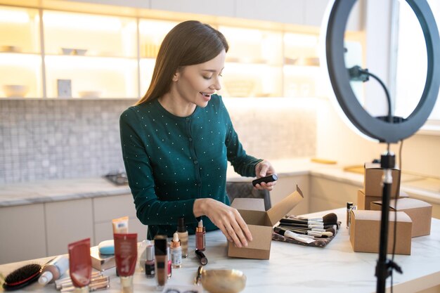 Young woman demonstrating new cosmetic products and looking involved