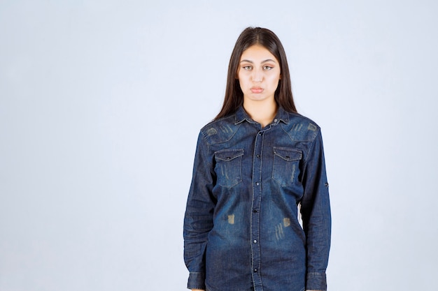 Free Photo young woman in denim shirt giving neutral poses without reactions