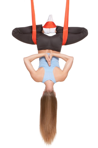 Free Photo young woman doing anti-gravity aerial yoga in hammock on white wall