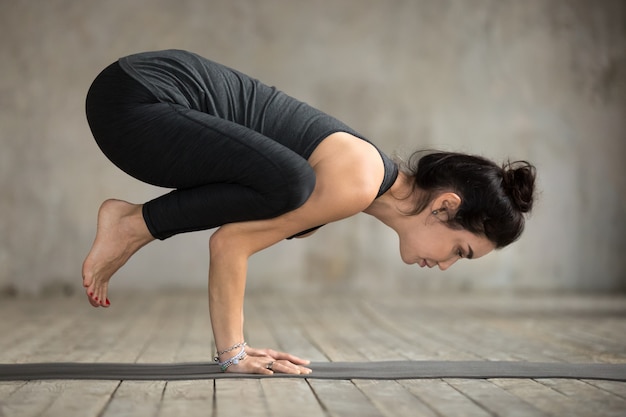 Free photo young woman doing crane exercise