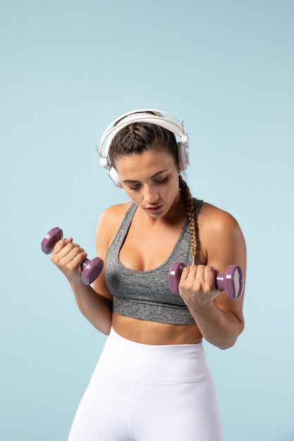 Young woman doing exercises with her headphones on