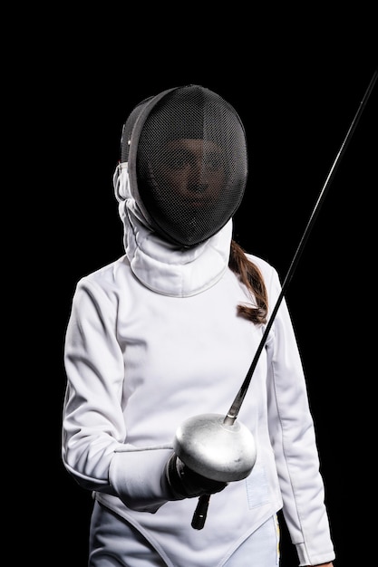 Young woman doing fencing in special equipment