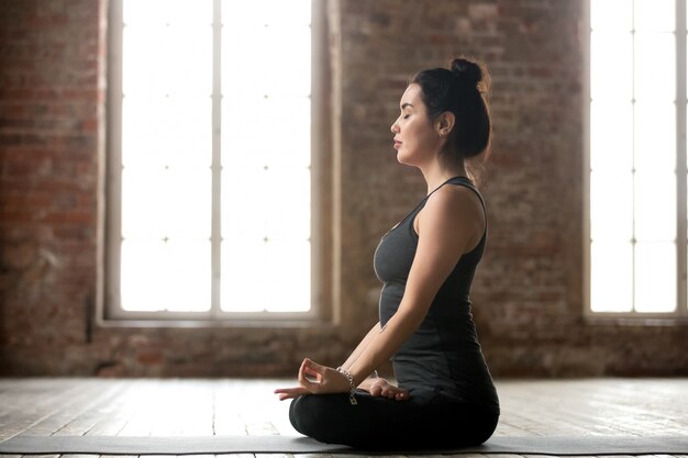 Young woman doing Padmasana exercise