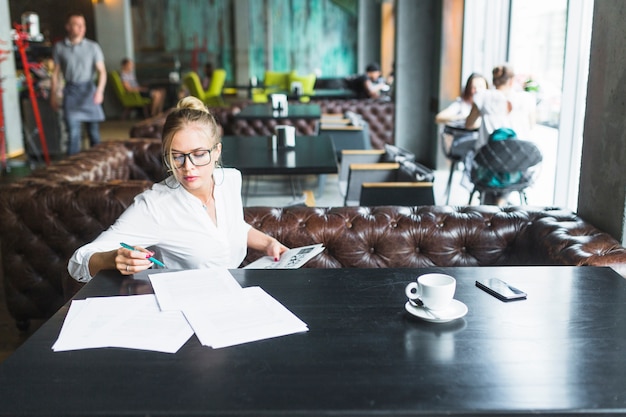 Young woman doing paperwork in restaurant