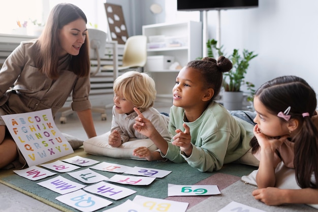 Free photo young woman doing speech therapy with children