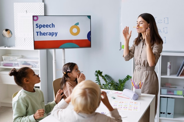 Young woman doing speech therapy with kids